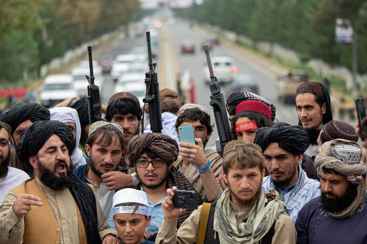 Taliban fighters hold rifles as they chant victory slogans at the Ahmad Shah Massoud Square in Kabul on August 15
