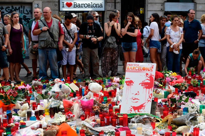 Un grupo de personas coloca flores y velas en uno de los homenajes populares de las víctimas del atentado en Las Ramblas, tres días después del atentado.