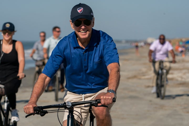 President Joe Biden rides a bicycle along the beach at Kiawah Island, S.C., on Aug. 14, 2022.