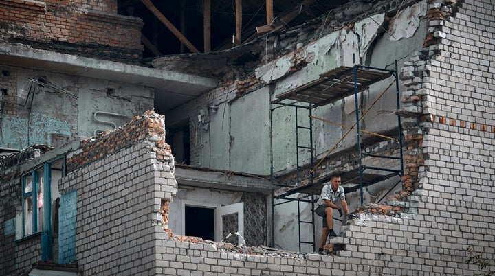 A man looks out from an apartment destroyed after Russian shelling in Nikopol, Ukraine, on Aug. 15, 2022.