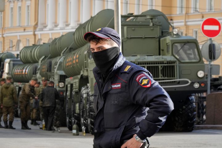 Ένας Ρώσος αστυνομικός μπροστά στους ρωσικούς εκτοξευτές αντιαεροπορικών πυραύλων S-400 που στέκονται έτοιμοι την παραμονή της στρατιωτικής παρέλασης της Ημέρας της Νίκης που έγινε στην πλατεία Dvortsovaya, στις 9 Μαΐου 2022, για τον εορτασμό των 77 χρόνων μετά τη νίκη στον Β' Παγκόσμιο Πόλεμο. Αγία Πετρούπολη, Ρωσία. (AP Photo/Dmitri Lovetsky)