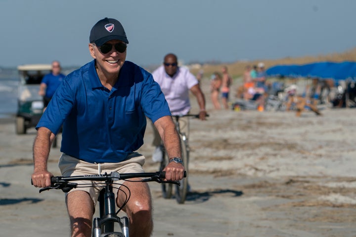 President Joe Biden rides a bicycle along the beach at Kiawah Island, South Carolina, on Aug. 14, 2022.