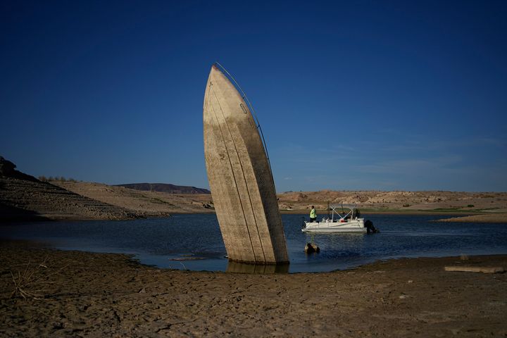 A formerly sunken boat sits upright into the air with its stern stuck in the mud along the shoreline of Lake Mead, near Boulder City, Nevada. (AP Photo/John Locher, File)
