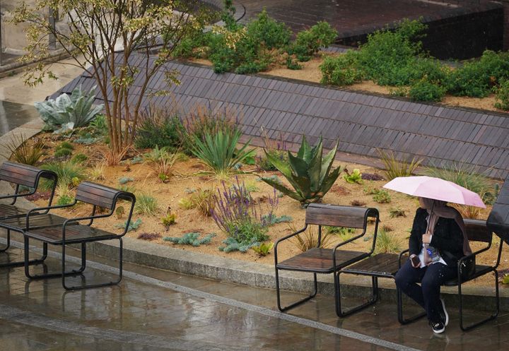 LONDON: A woman sat on a park bench with an umbrella shelters from the rain near Blackfriars in London.