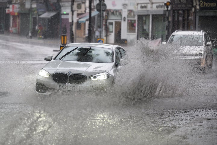 A car negotiates a flooded section of road in London, as torrential rain and thunderstorms hit the country.