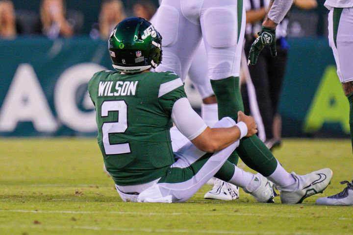 New York Jets quarterback Zach Wilson holds his knee after injuring it during a preseason game against the Philadelphia Eagles on Friday.