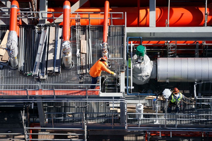 In this Nov. 16, 2015 photo, employees work next to the gas lines of the Mississippi Power Co. carbon capture power plant in DeKalb, Mississippi.