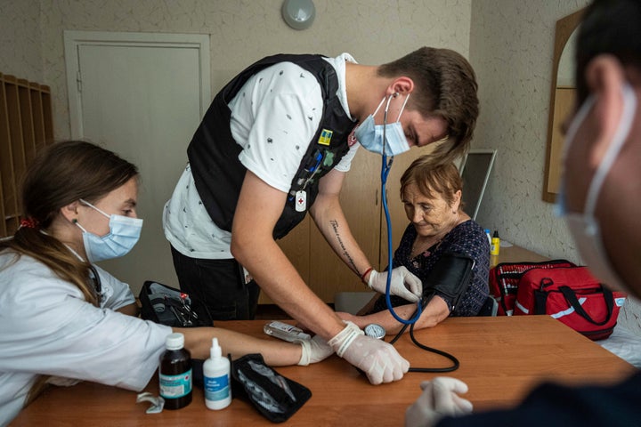 Medics from the Ukrainian Red Cross take the blood pressure of a patient at the center for displaced persons near Mykolaiv, Kharkiv region, Ukraine, on Aug. 8, 2022.