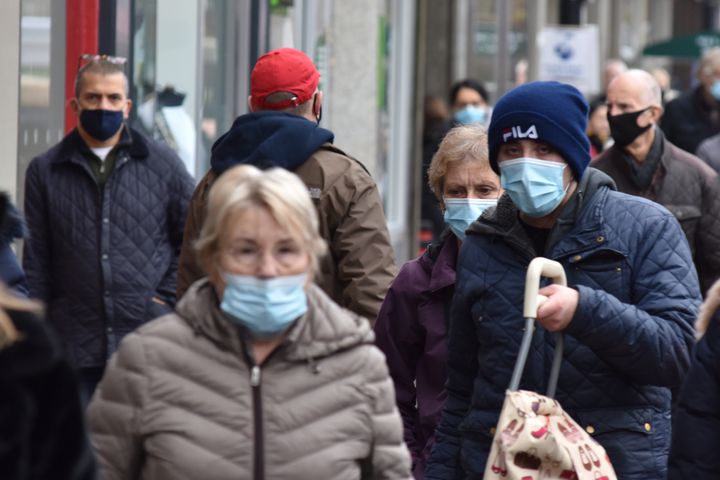 Pedestrians wear face masks as they walk along the High Street on December 11, 2020
