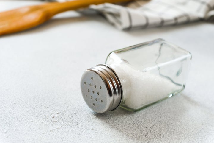 A new clean Wooden spatula, a kitchen towel and a salt shaker on the dining table. The concept of cooking in a restaurant and cafe, at home in the kitchen. Cook it yourself, taking courses on the ability to cook delicious and beautiful food. Copy space.