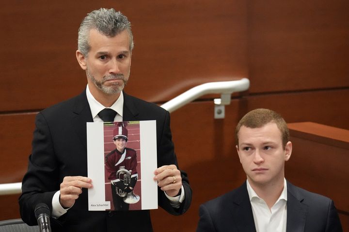 Max Schachter, with his son Ryan, by his side, holds a photo of his other son, Alex, who died in the shooting at the age of 14.  Cruz previously pleaded guilty to 17 counts of premeditated murder and 17 counts of attempted murder in the 2018 shooting.