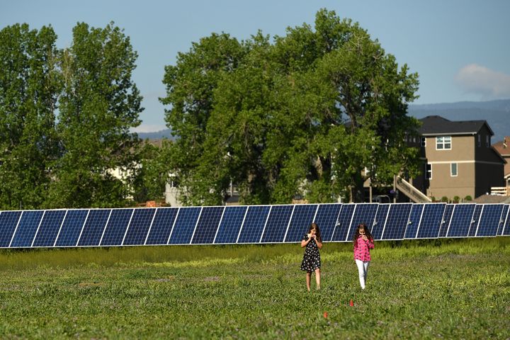 The daughter of state Sen. Kevin Priola and the daughter of SunShare's director of legislative affairs Corrina Kumpe walk among the solar panels at the JeffCo Community Solar Garden in Arvada, Colorado, on May 30, 2019. Priola announced he is switching party affiliations on Aug. 22, 2022, citing the GOP's peddling of election lies and its refusal to work on climate policy.