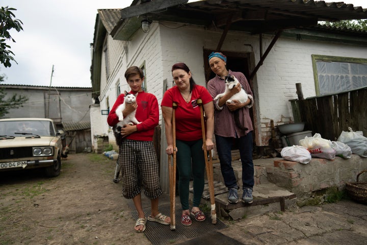 Danyk Rak, 12, his mother Liudmila Koval, centre, and grandmother Nina stand in the village of Voznesenske, near Chernihiv, Ukraine, on Aug. 13, 2022.