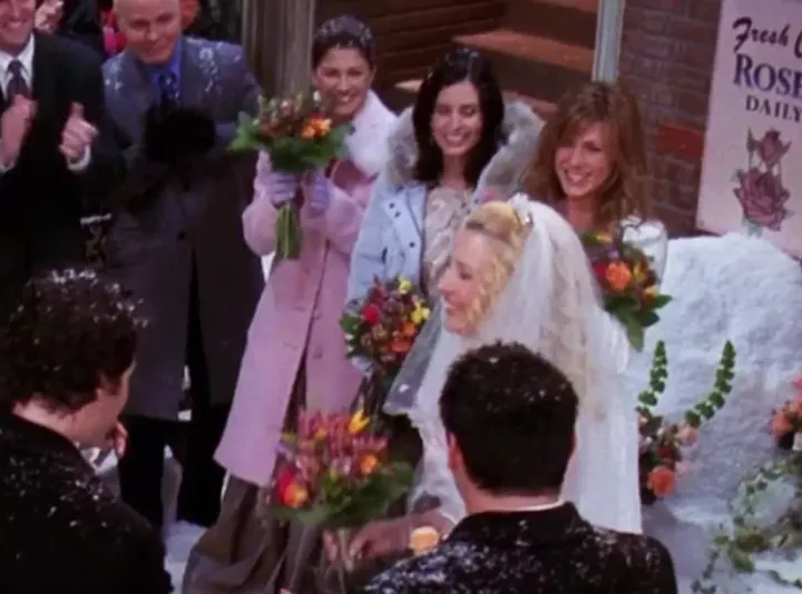 Phoebe on her wedding day watched by her three bridesmaids, Rachel, Monica and a mysterious third.