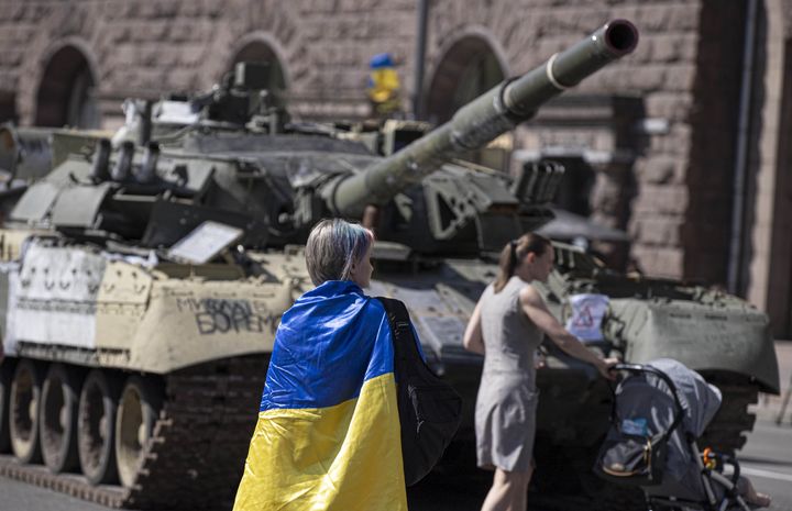 A Ukrainian woman is seen with a Ukraine flag in front of the tank, captured by Ukrainian forces during the war against Russia, during Ukraine's 31st Independence Day in Kyiv, Ukraine on August 24.