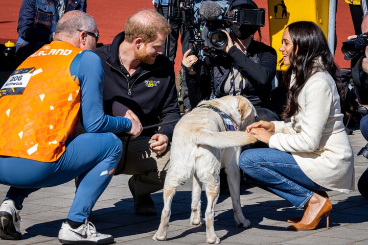 The Duke and Duchess of Sussex meet a dog as they attend the Invictus Games on April 17 in the Netherlands.