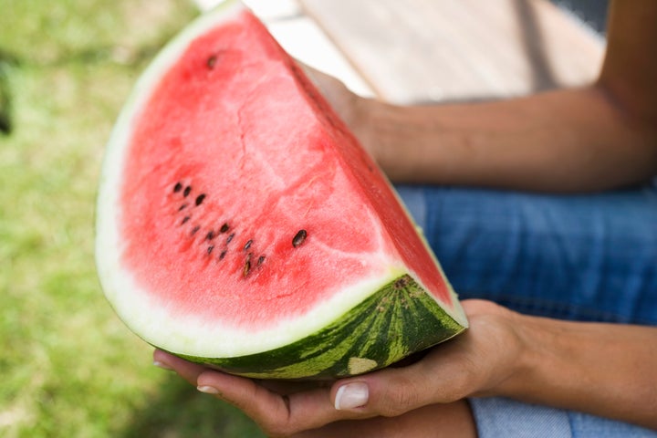 Hands holding a slice of watermelon