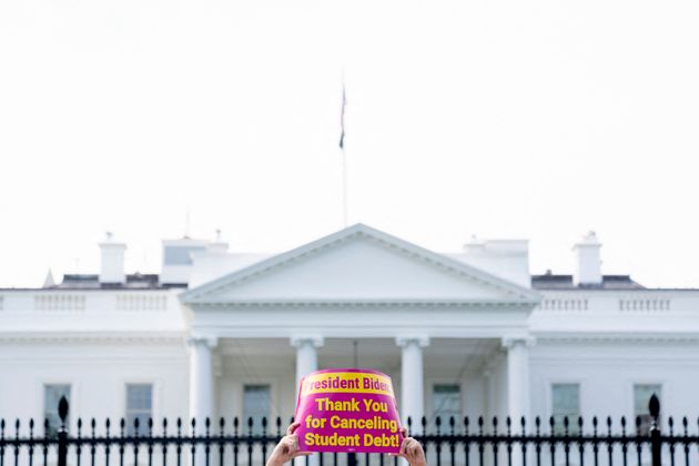 ホワイトハウスの前で「学生ローンを免除してくれてありがとう」というプラカードを掲げる人（2022年8月25日）