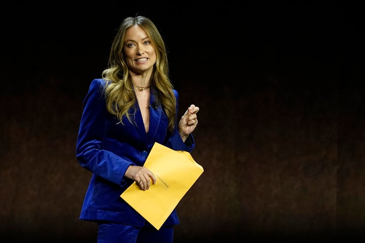 Wilde at CinemaCon 2022 in April, holding an envelope with custody papers.