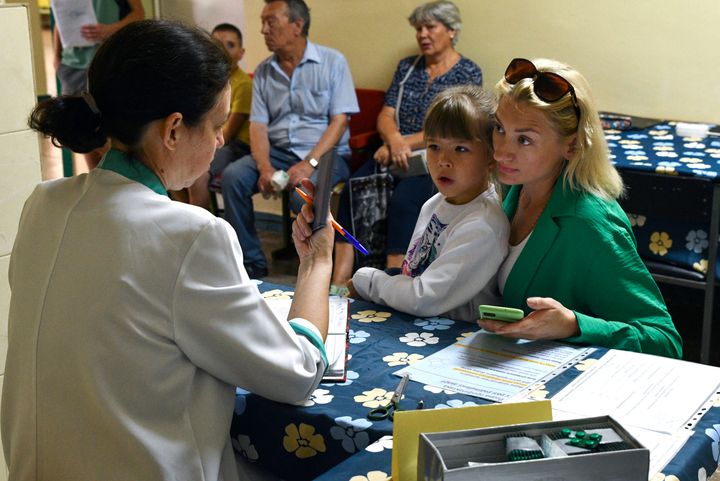 People receive iodine-containing tablets at a distribution point in Zaporizhzhia, Ukraine, Friday, Aug. 26, 2022.
