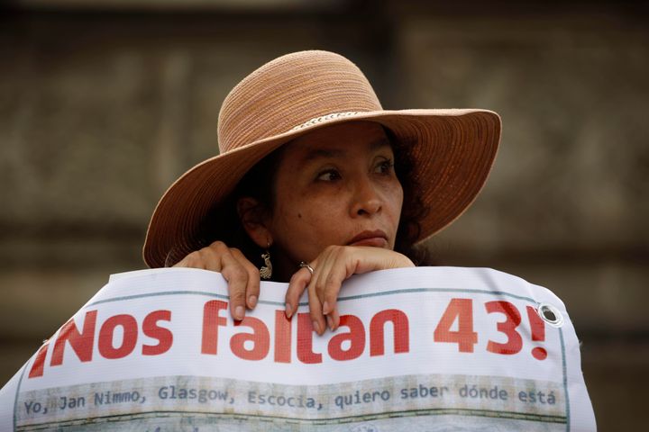 A woman carries a banner that reads in Spanish "We are missing 43," referring to the 43 missing students from a rural teachers college during a march in Mexico City, Thursday, Nov. 26, 2015. 