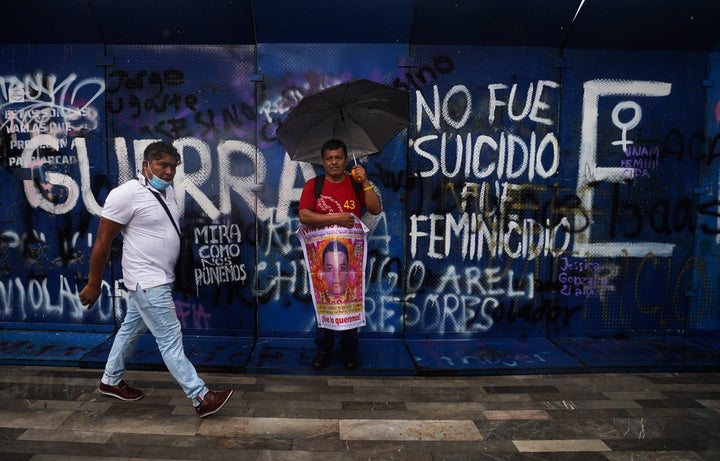 Clemente Rodriguez holds a poster of his missing son Christian, during a march seeking justice for the missing 43 Ayotzinapa students, in Mexico City, Friday, Aug. 26, 2022.