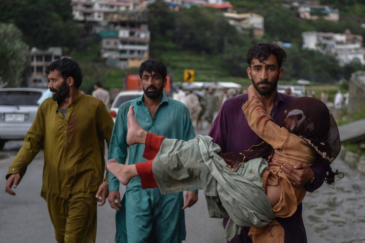 A man carries his sick daughter through the flood-ravaged Swat Valley in the north.