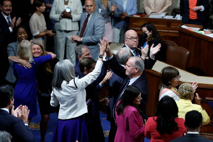 Democratic members of the House celebrate on the House floor after passage of the Inflation Reduction Act on Aug. 12. The bill passed with 158 members voting by proxy, which allows them to have their votes counted despite being physically absent.