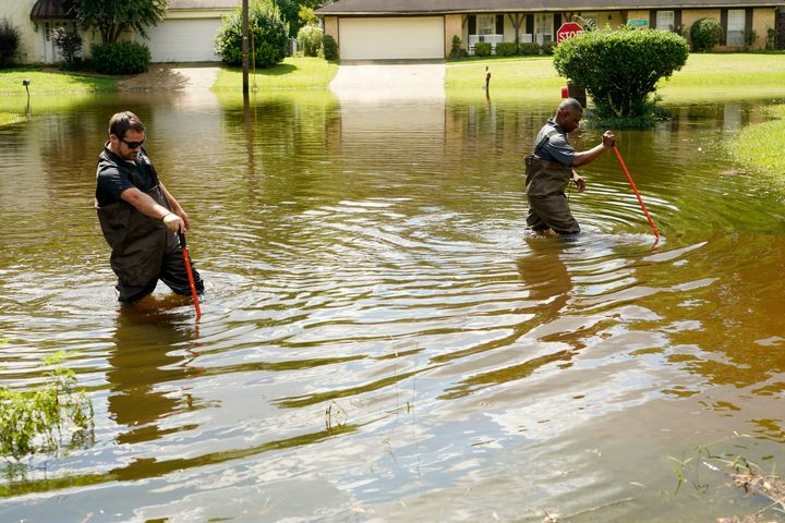 Hinds County Emergency Management Operations deputy director Tracy Funches, right, and operations coordinator Luke Chennault, wade through flood waters in northeast Jackson, Mississippi, on Monday.