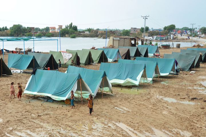 Children walk past tents set up for people displaced due to flooding in Dera Allah Yar town after heavy monsoon rains in Jaffarabad district, Balochistan province on Aug. 30.