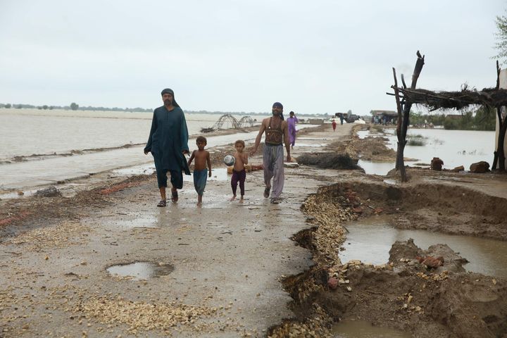 Displaced people are seen at a flooded area following the deadly climate catastrophe in Dadu, Pakistan on Aug. 29.