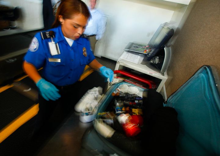 TSA職員が旅行者の荷物を調べている（イメージ画像）