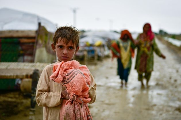 パキスタン南西部のバロチスタン州で物を持つ子ども（2022年8月18日撮影）© UNICEF/UN0691098/Sami Mali