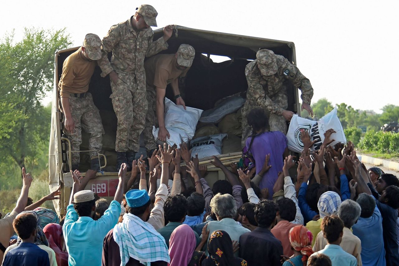 Army soldiers distribute relief food bags to flood affected people in Shikarpur of Sindh province on Aug. 28, 2022.