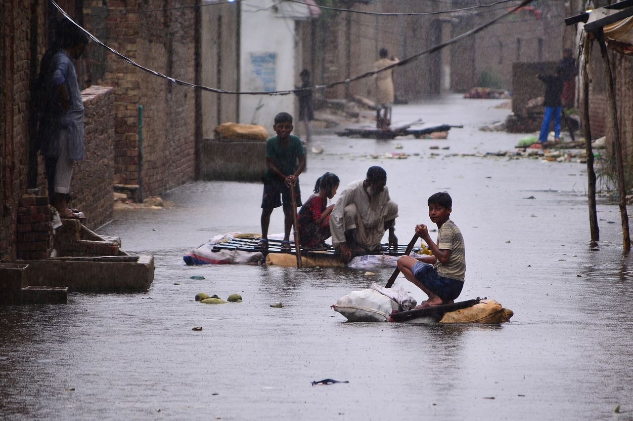 Residents use rafts to make their way along a waterlogged street in a residential area after a heavy monsoon rainfall in Hyderabad on August 24, 2022. Record monsoon rains were causing a "catastrophe of epic scale", Pakistan's Climate Change Minister said August 24, announcing an international appeal for help in dealing with floods that have killed more than 800 people since June. 
