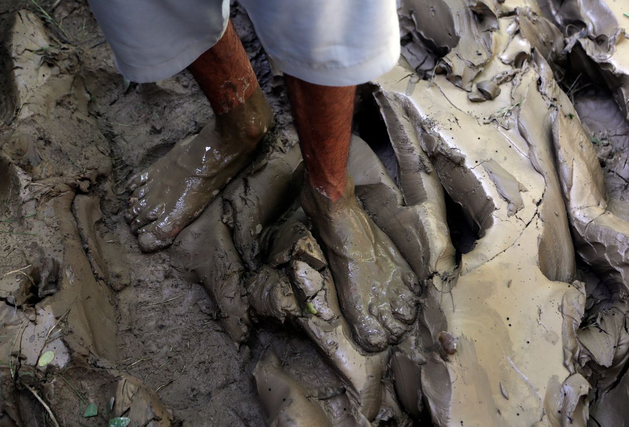 A man stand in mud after floodwaters hit his home, in Charsadda, Pakistan on Aug. 30, 2022. 
