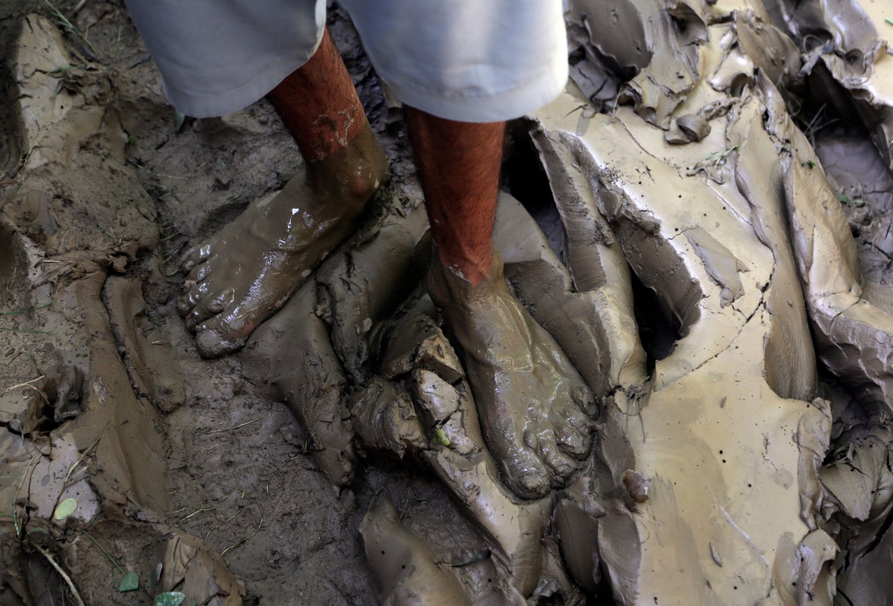 A man stand in mud after floodwaters hit his home, in Charsadda, Pakistan on Aug. 30, 2022.