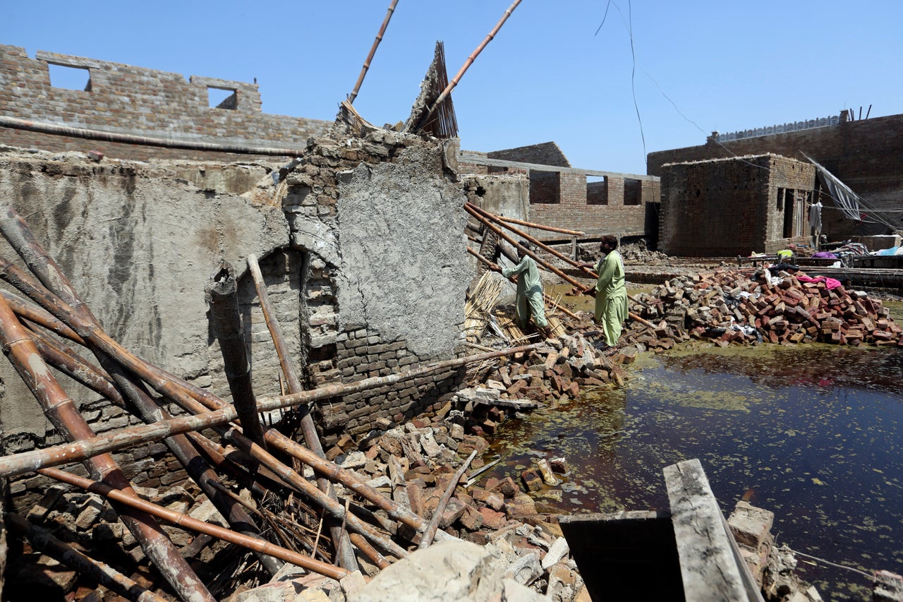A family look for salvageable belongings from the remains of their flood-hit home in Shikarpur district of Sindh province, of Pakistan on Aug. 31, 2022.