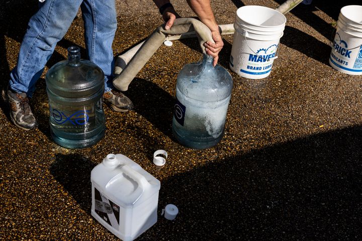 Ty Carter, with Garrett Enterprises, fills jugs with non-potable water at Forest Hill High School on August 31, 2022 in Jackson, Mississippi. Jackson, the state’s capital, is currently struggling with access to safe drinking water after disruption at a main water processing facility.