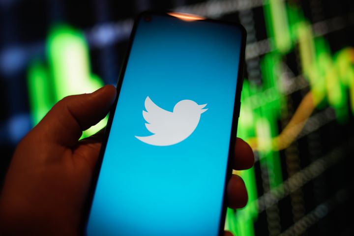 The Twitter logo is seen on a phone screen.