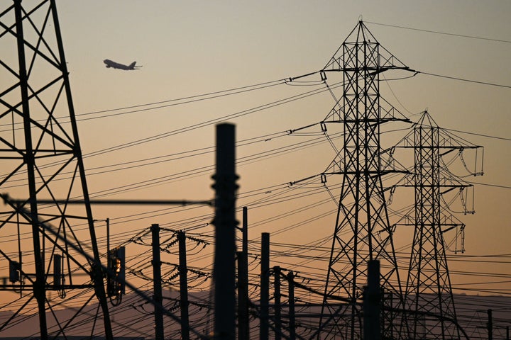 A plane is seen taking off behind power lines in El Segundo, California, as authorities urged energy conservation across the state on Wednesday, Aug. 31.