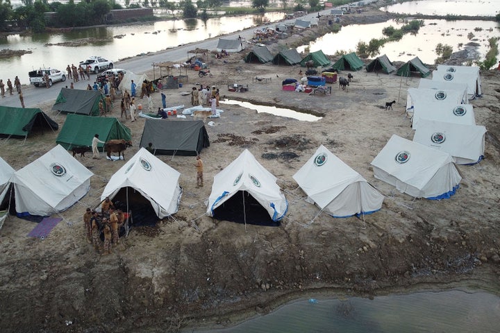 This aerial photograph taken on September 3, 2022, shows the Pakistani army as they arrive to help flood-affected people at a makeshift camp after heavy monsoon rains at Sohbatpur in the Jaffarabad district of the Balochistan province. Monsoon rains have submerged a third of Pakistan, claiming at least 1,300 lives since June and unleashing powerful floods that have washed away swathes of vital crops and damaged or destroyed more than a million homes.