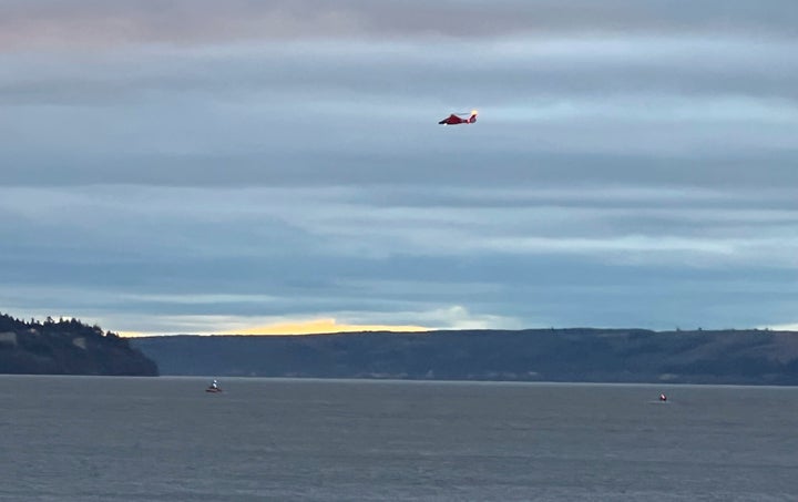 A Coast Guard helicopter searches the area where a floatplane crashed near Whidbey Island, Wash., on Sept. 4, 2022.