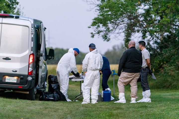 Investigators gather in front of a table near the scene of stabbing in Weldon, Saskatchewan on Sept. 4, 2022. A series of stabbings at an Indigenous community and at another in the village of Weldon left multiple people dead and others wounded, Canadian police said Sunday as they searched for two suspects. 