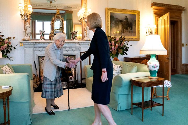 Britain's Queen Elizabeth II, left, welcomes Liz Truss during an audience at Balmoral, Scotland, where she invited the newly elected leader of the Conservative party to become Prime Minister and form a new government, on Sept. 6, 2022.