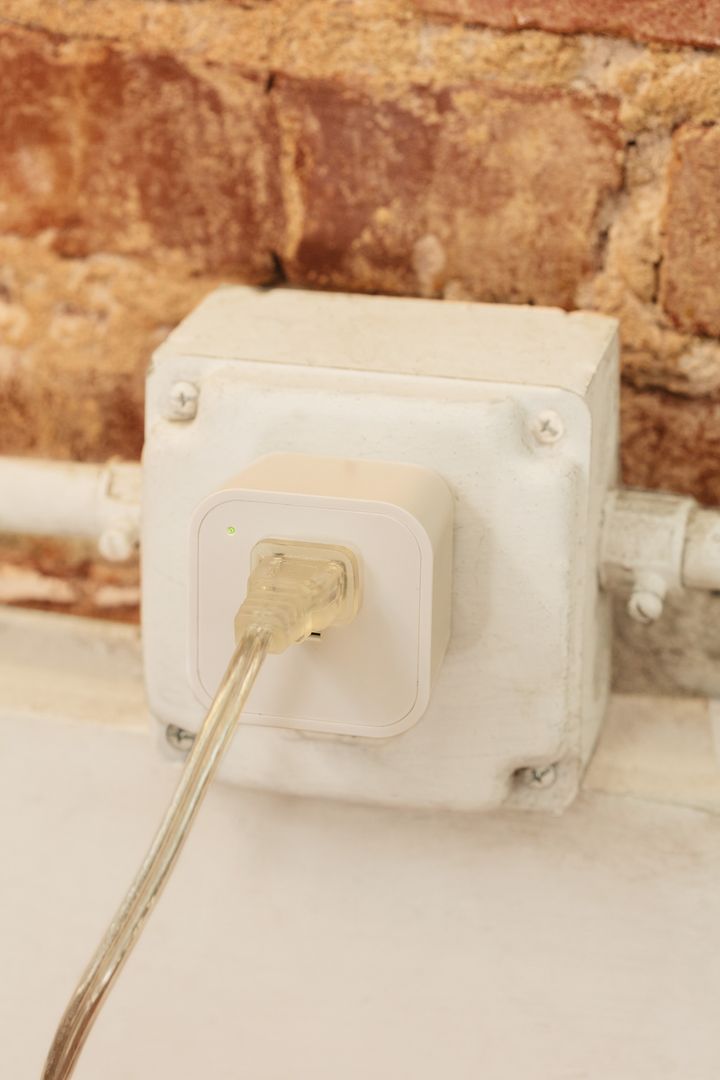 Cord plugged into smart plug on brick wall