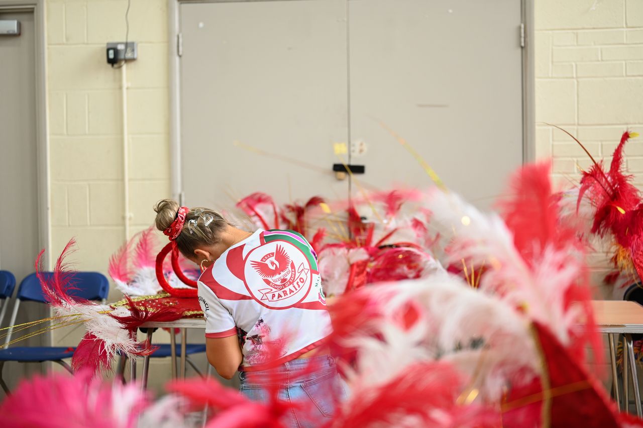 A passista dancer for the Paraiso School of Samba makes adjustments to her Carnival costume.