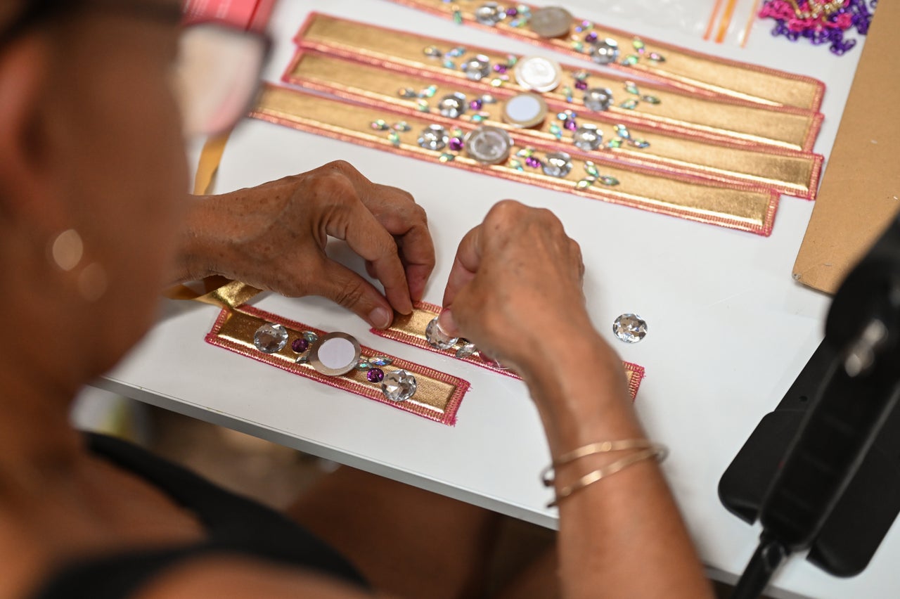 Team member Caroline glues gems onto costumes ahead of Notting Hill Carnival. 