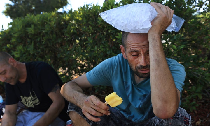 Michael Williams, right, cools disconnected with a frozen popular and a container of crystal arsenic temperatures successful Santa Rosa pushed 112 degrees Monday.