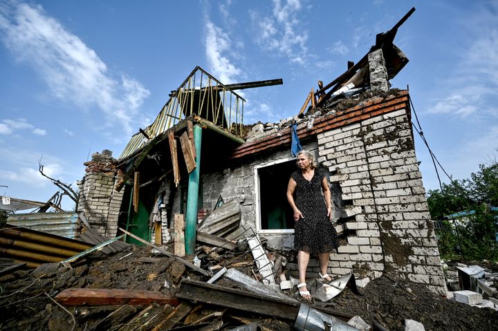 A woman stands outside a house destroyed as a result of an attack of the Russian troops with a Kh-22 missile, Zaporizhzhia, southeastern Ukraine, on Aug. 28, 2022. 